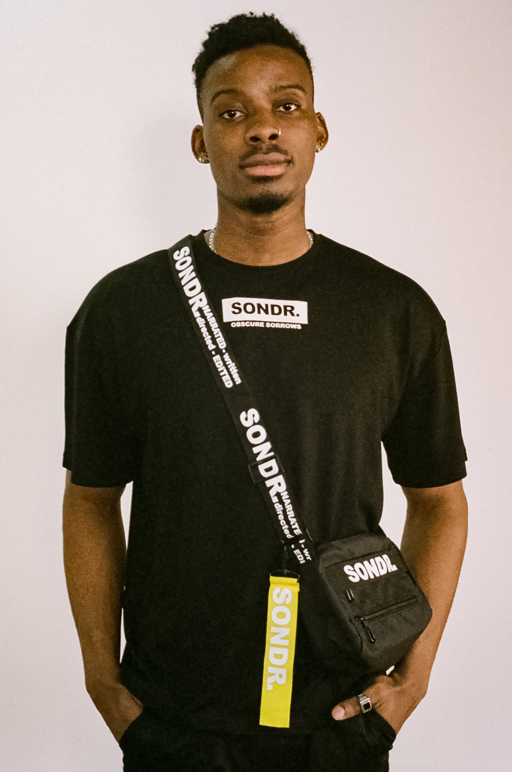 Image of Joseph Peters from Project Peters wearing a Black SONDR. Side Bag & Black SONDR. Logo T-shirt with his hands in his pockets.
